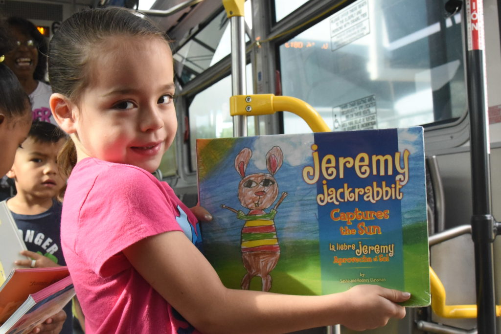 child with books donated by bus driver