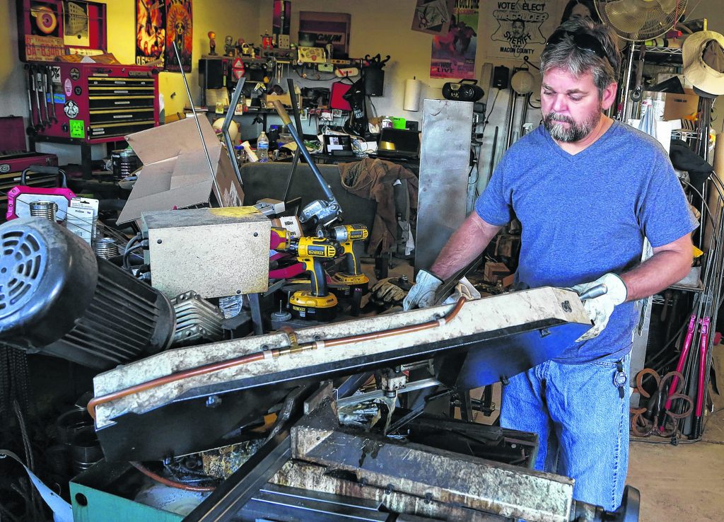 Metal sculptor, Jeff Walker, cuts pieces of metal for a frame that will be used for a mirror. Walker has been creating art for 20 years but has been doing it professionally for three years. He uses mostly steel and stainless steel but also works with copper and bronze. Wrangler News photo by Ana Ramirez