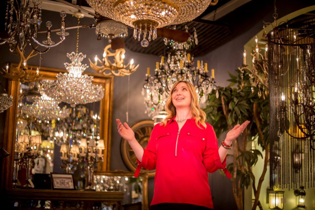 Dawn Stantus expresses wonderment at the dazzling array of lighting in the showroom that's her home away from home. Store (right) features an array of styles, choices. (Photo by Billy Hardiman/Wrangler News)